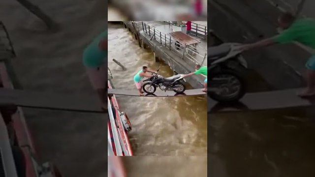 Pushing a motorcycle into a boat. It couldn't work