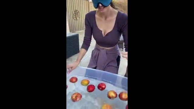 Pretty girl catches apples out of the water