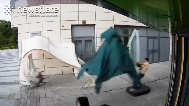 Man Surfs Umbrella Down Street In Strong Wind [VIDEO]