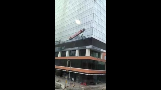 Horrifying moment a window washer FALLS from his platform in high wind