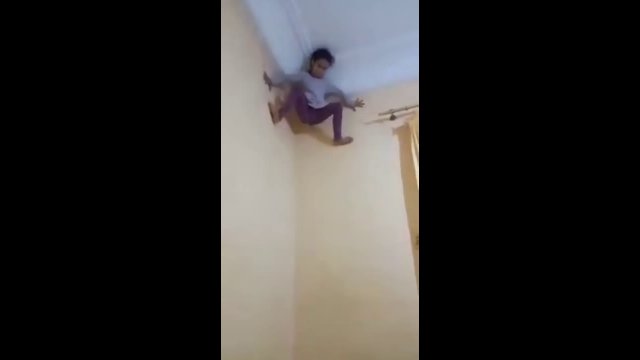 A child climbs onto the wall like a spider-man