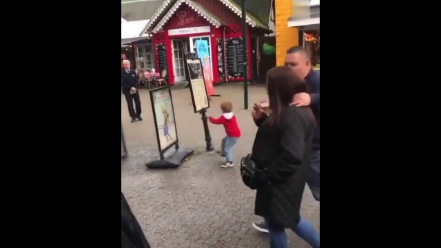 The young boy attempted to knock over an advertising sign