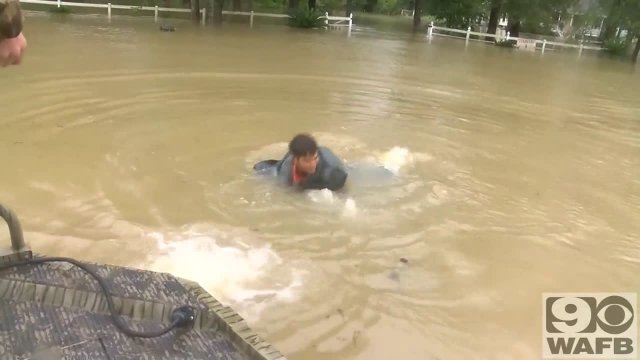 A man rescues a woman and her dog from a sinking vehicle
