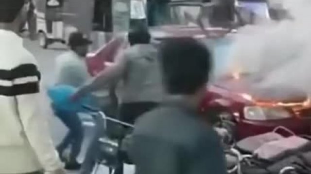 Deranged man throws chair at burning car