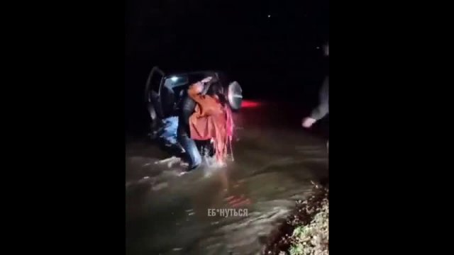 A gentleman carries a woman through a flood