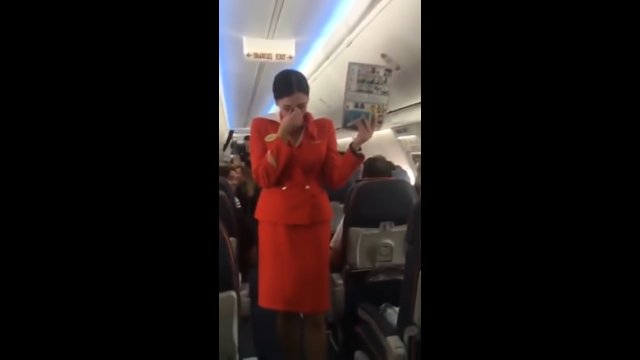 Football fans distract a stewardess in flight