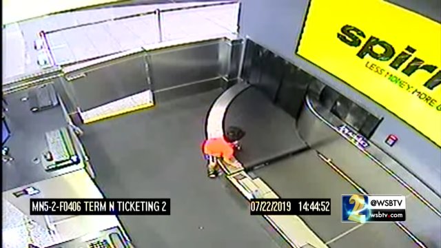 A 2-year-old takes a ride on the baggage carousel to the airport's baggage sorting area